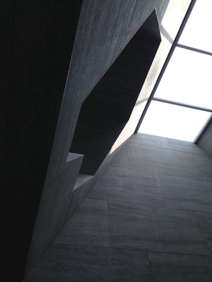 Low angle view of a modern geometric architectural interior with skylight, minimalist design.